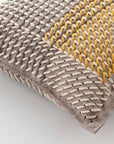 Detalje af gul og grå pude fra CANEVAS GEO kollektionen, der fremhæver det taktile og lagdelte broderi.