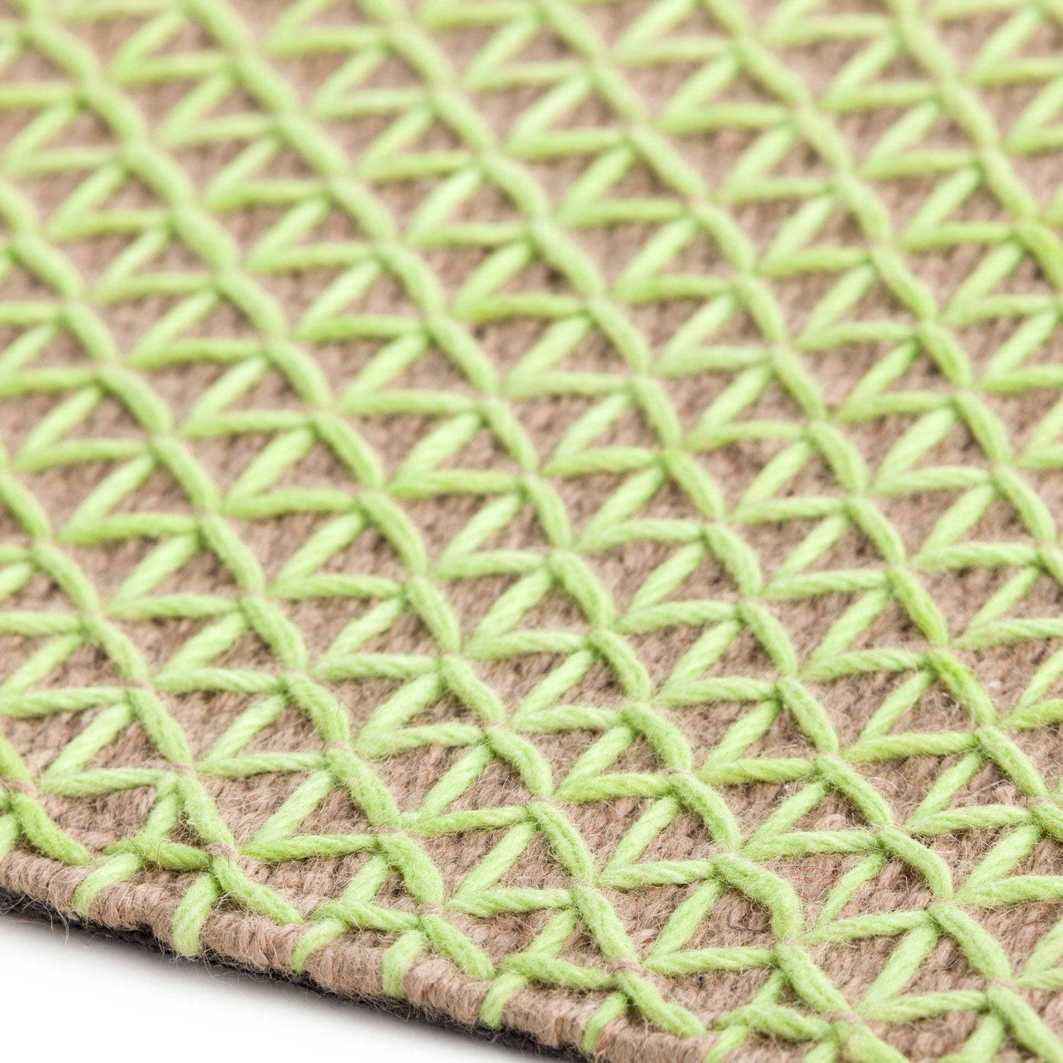 Detaljebillede af RAW Tæppe i grøn farve med tæt vævet uldstruktur og jute-base.